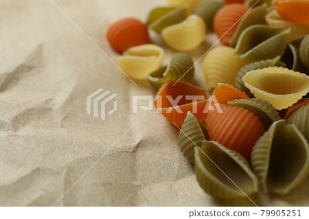 Uncooked pasta on craft paper, space for text Uncooked pasta on craft paper, space for text 79905251