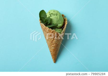 Cone of mint ice cream on blue background Cone of mint ice cream on blue background 79905284