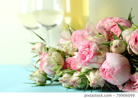 Romantic concept with roses and wine on blue table Romantic concept with roses and wine on blue table 79906099
