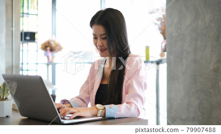 Shot of an attractive businesswoman working on laptop in her modern workstation. Shot of an attractive businesswoman working on laptop in her modern workstation. 79907488