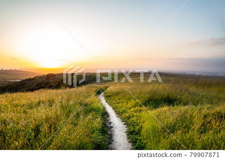 A straight straight road in the meadow against the backdrop of dusk A straight straight road in the meadow against the backdrop of dusk 79907871