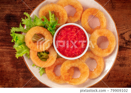 Squid rings close-up on a wooden background. Deep fried calamari rings Squid rings close-up on a wooden background. Deep fried calamari rings 79909102