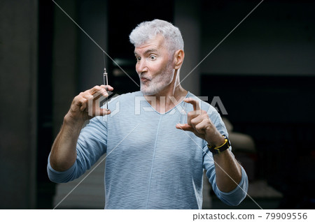 Emotional Handsome gray haired senior man vaccinated with a syringe. Immunization and health concept Emotional Handsome gray haired senior man vaccinated with a syringe. Immunization and health concept 79909556