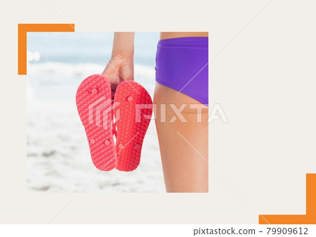 Photograph of mid section of woman holding flip flops at the beach against grey background Photograph of mid section of woman holding flip flops at the beach against grey background 79909612