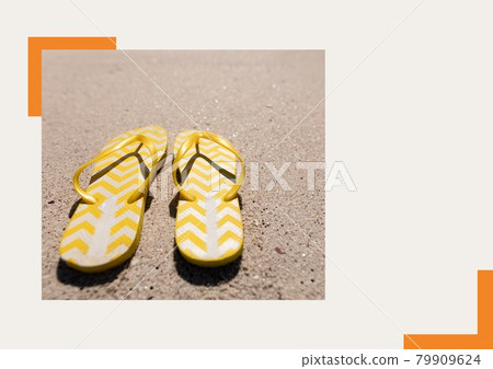 Photograph of yellow flip flops at the beach against grey background Photograph of yellow flip flops at the beach against grey background 79909624