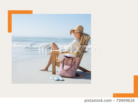 Photograph of caucasian woman sitting on a chair smiling at the beach against grey background 79909626