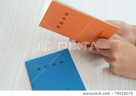 A woman is looking at her pension book. 79910079