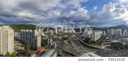 Panoramic view of city and sky filled with clouds Panoramic view of city and sky filled with clouds 79910330
