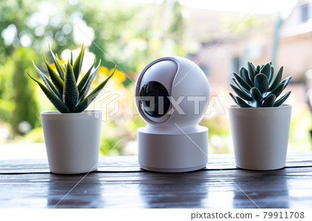 Video surveillance equipment on the table. Compact security camera for outdoor or private home security Video surveillance equipment on the table. Compact security camera for outdoor or private home security 79911708