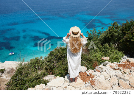 Woman in hat looking at beautiful blue lagoon 79922282