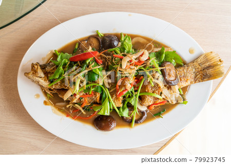 deep fried sea bass fish with sweet sauce and trimmings deep fried sea bass fish with sweet sauce and trimmings 79923745