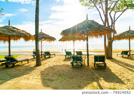 umbrella and beach chair with coconut palm tree and sea beach background and blue sky 79924092
