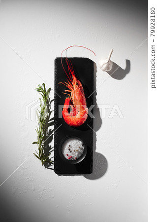 One cooked shrimp with condiments, garlic and rosemary One cooked shrimp with condiments, garlic and rosemary 79928180