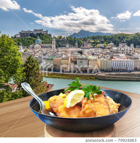 Traditional Austrian gastronomy( Schnitzel) against Salzburg with castle in Austria 79928863
