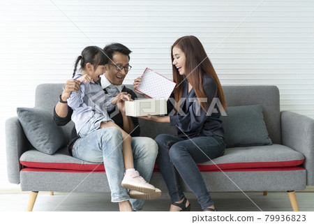Asian mother and father give present for daughter. concept surprise gift box for happy birthday.. Asian mother and father give present for daughter. concept surprise gift box for happy birthday.. 79936823