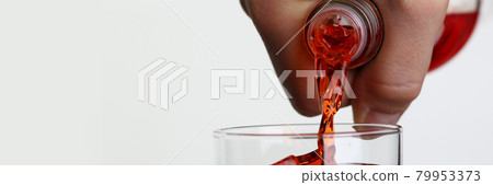 Man pouring orange drink into glass with ice closeup Man pouring orange drink into glass with ice closeup 79953373
