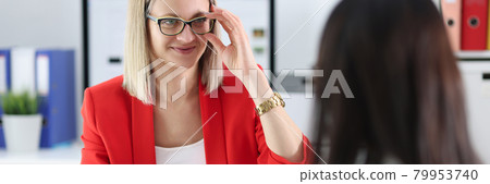 Business woman with glasses communicating with colleague at table Business woman with glasses communicating with colleague at table 79953740