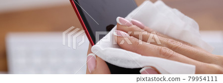 Woman wiping screen of mobile phone with damp cloth closeup 79954111