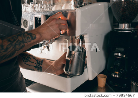 Barista shaking milk for invigorating drink, sweet cappuchino or latte. Close up image 79954667