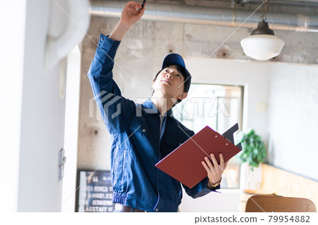 Young worker checking the air conditioner 79954882
