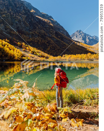 Hiker happy woman nearly crystal lake in autumnal mountains. Hiker happy woman nearly crystal lake in autumnal mountains. 79955359