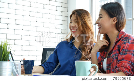 Happiness two women working together confident team meeting in office desk. Team business partners working with computer laptop startup company. Asian colleague friendship at work with smiling face. Happiness two women working together confident team meeting in office desk. Team business partners working with computer laptop startup company. Asian colleague friendship at work with smiling face. 79955678
