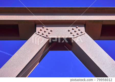 Pink painted steel girder of a tied arch bridge in front of a blue sky, abstract cutout Pink painted steel girder of a tied arch bridge in front of a blue sky, abstract cutout 79956012