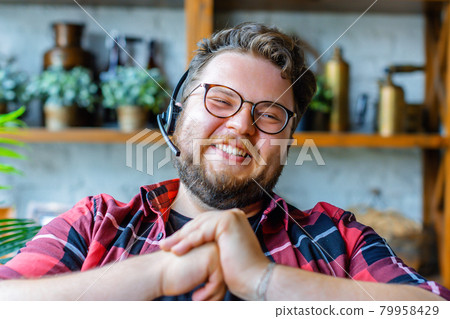 Happy laughing young man in headset during online video call. 79958429