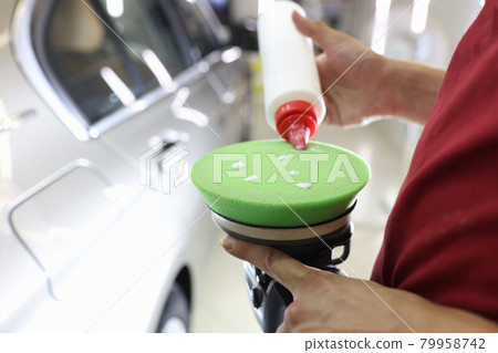 Male polisher applies protective wax to car polishing machine Male polisher applies protective wax to car polishing machine 79958742