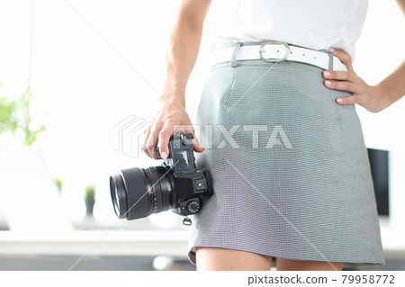 Woman holds in hand black modern photo camera Woman holds in hand black modern photo camera 79958772