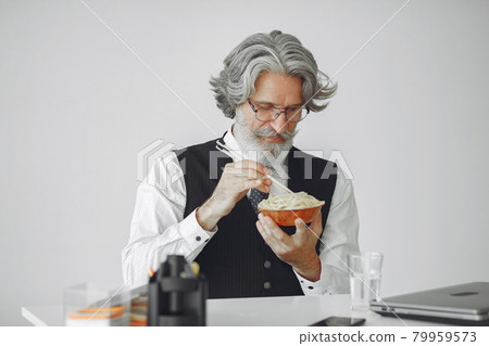 Handsome pensive mature businessman with pasta Handsome pensive mature businessman with pasta 79959573