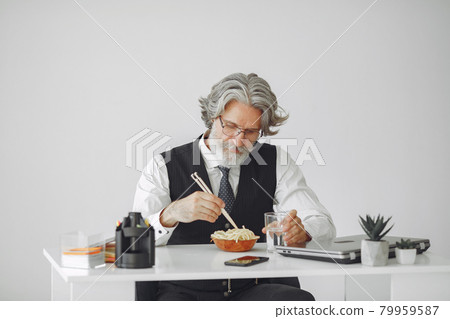 Handsome pensive mature businessman with pasta Handsome pensive mature businessman with pasta 79959587