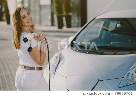 Woman charging electro car at the electric gas station 79959701