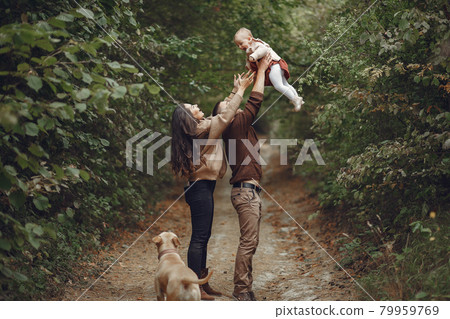 Cute and stylish family playing in a autumn field Cute and stylish family playing in a autumn field 79959769