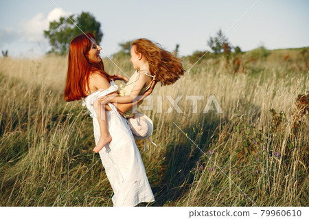 Mother with daughter playing in a summer field 79960610