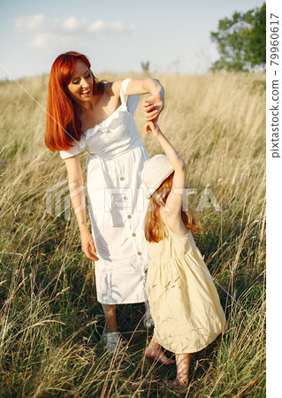 Mother with daughter playing in a summer field Mother with daughter playing in a summer field 79960617
