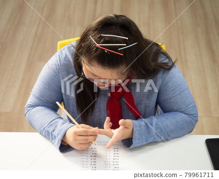 Cute Down Syndrome girl doing hand counting in math class. Concept disabled child learning in school. Cute Down Syndrome girl doing hand counting in math class. Concept disabled child learning in school. 79961711