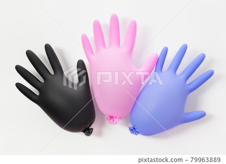 Multicolored inflated medical gloves on a white background. Protection from coronavirus. Personal hygiene concept. Multicolored inflated medical gloves on a white background. Protection from coronavirus. Personal hygiene concept. 79963889
