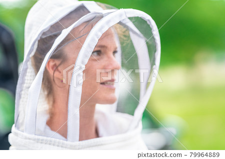 woman beekeeper in protective suit in beekeeping woman beekeeper in protective suit in beekeeping 79964889