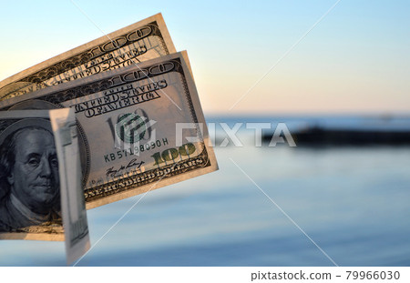 Three hundred dollar bills on background of sea surface. 100 dollar Three hundred dollar bills on background of sea surface. 100 dollar 79966030