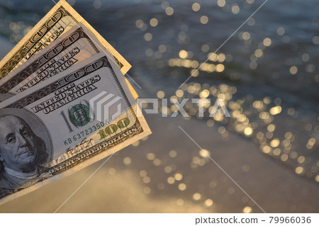 Three hundred dollar bills on background of sea surface. 100 dollar cash Three hundred dollar bills on background of sea surface. 100 dollar cash 79966036