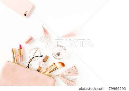 Flat lay composition with pink cosmetic bag with cosmetic makeup products, isolated on white background. Flat lay, top view. Flat lay composition with pink cosmetic bag with cosmetic makeup products, isolated on white background. Flat lay, top view. 79966293
