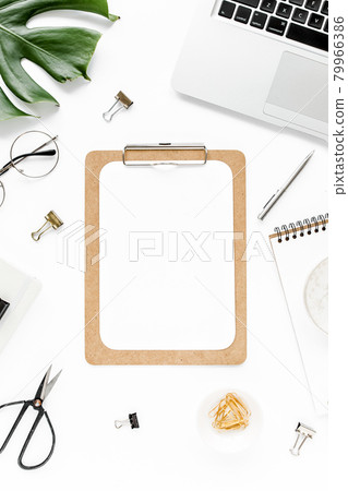 Home office workspace mockup with laptop, tropical leaves Monstera, clipboard, notebook and accessories on white background. Flat lay, top view 79966386