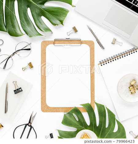 Home office workspace mockup with laptop, tropical leaves Monstera, clipboard, notebook and accessories on white background. Flat lay, top view Home office workspace mockup with laptop, tropical leaves Monstera, clipboard, notebook and accessories on white background. Flat lay, top view 79966423