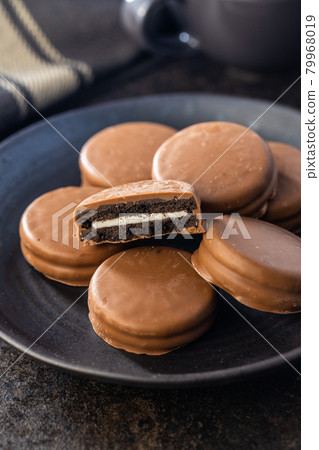 Biscuits with chocolate icing on plate. 79968019