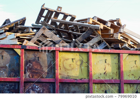 Garbage removal. Pile of wooden pallet waste on background blue sky Garbage removal. Pile of wooden pallet waste on background blue sky 79969010