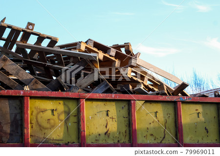 Garbage removal. Pile of wooden pallet waste on background blue sky Garbage removal. Pile of wooden pallet waste on background blue sky 79969011
