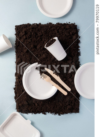 Single-use tableware dinnerware popular non-plastic alternatives on ground on blue flat lay composition, top view. Compostable or biodegradable dinnerware concept 79970119