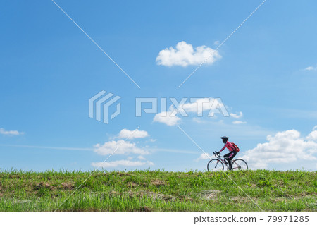 騎自行車的騎手在多摩川的堤岸上奔跑的形象 騎自行車的騎手在多摩川的堤岸上奔跑的形象 79971285