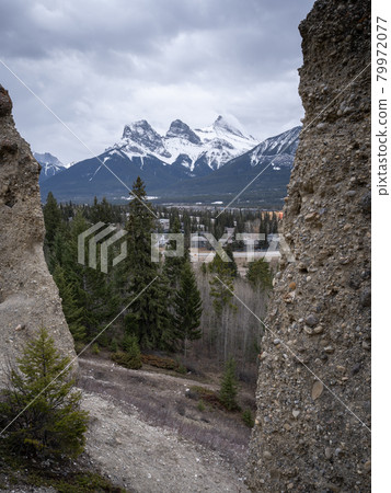 Three sisters mountain above Canmore framed by hoodoos, shot at Canmore, Alberta, Canada 79972077